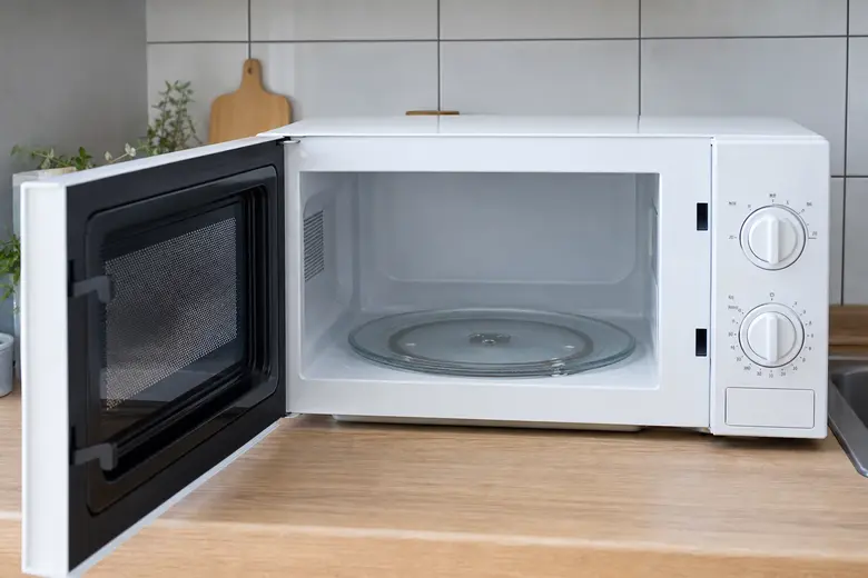Four à micro-ondes ouvert sur un plan de travail de cuisine, cavité intérieure visible